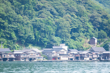 Fototapeta na wymiar 日本の京都府伊根町の伊根の舟屋の風景。遠い子供時代を思い起こす懐かしい街並みが広がっています。