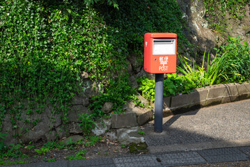 日本の田舎にある古い郵便ポストに日の光がさしていて趣のある雰囲気を醸し出している。