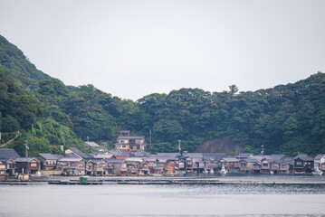 Fototapeta na wymiar 京都府伊根町の街並みで、海辺にたたずむ古民家の風景は、伊根の舟屋と呼ばれています。