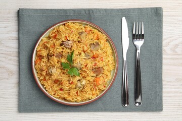 Delicious pilaf with meat served on white wooden table, top view
