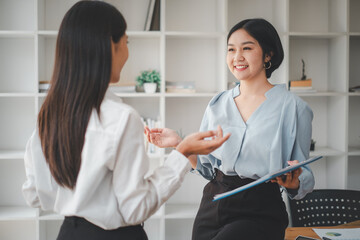 Female operations manager holds meeting presentation for a team of economists. Asian woman uses business paper with Growth Analysis, Charts, Statistics and Data.