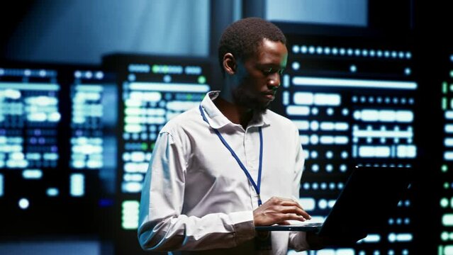 African american meticulous employee walking through server rows providing vast computing resources and storage, enabling artificial intelligence to process massive datasets for training and inference