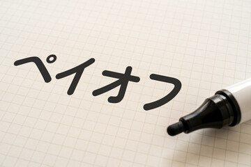 ペイオフと書かれたノートとマーカー