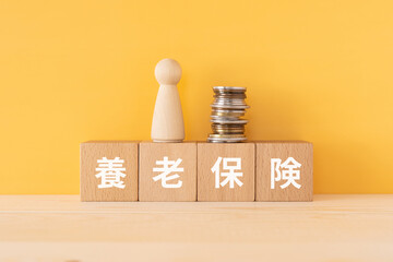 養老保険と書かれたブロックと人形とお金