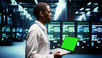 Engineer using green screen laptop to do maintenance on high bandwidth, dedicated game servers used to accommodate incoming traffic of online users joining from worldwide locations. - Powered by Adobe