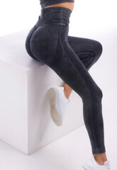 Beautiful young woman, dressed in a sports uniform, posing in the studio on a gray background....