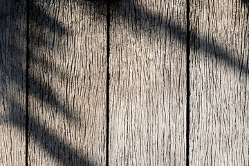 The shadow of leaf on a wooden surface