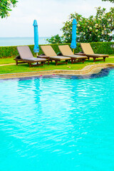 chair pool and umbrella around swimming pool