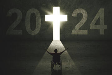 Silhouette of disabled man sitting in a wheelchair in 2024