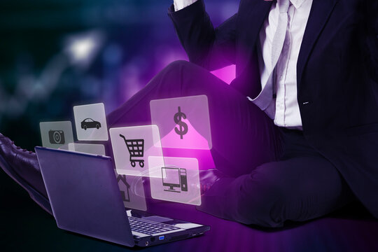 Businessman with laptop and holographic projections floating around