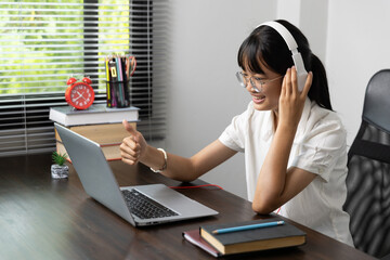 Student girl happy studying online, back to school concept. Young woman student busy study make notes in notebook and using laptop concentrated online training course technology education.