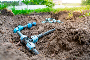 Plastic pipes and circuit wiring for lawn irrigation. Connection fittings and valves for shutting...