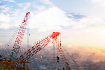 the tower crane and mobile crane and collar crane and construction site in the afternoon time with sunset. there are slings, and hooks, to try to build the city. - obrazy, fototapety, plakaty