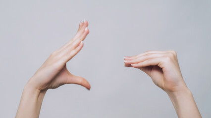 Empty promises. Blah gesture. Woman hands arguing showing naughty conflict quarrel isolated on gray...