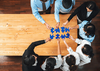 Multiethnic business people holding jigsaw pieces and merge them together as effective solution...