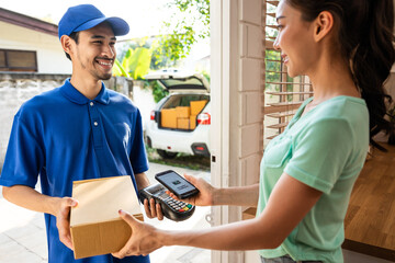Asian young delivery man delivering package to woman customer at home. 