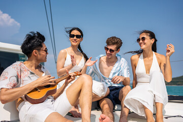 Group of diverse friend sit on deck of yacht while yachting together. 