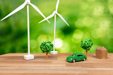 Green eco car and windmill turbine model with park on office table design. Sustainable and...