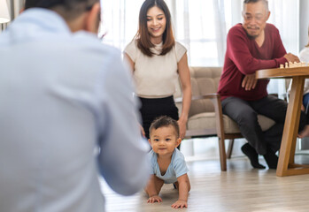 Portrait of enjoy happy love family asian mother playing and teaching help adorable little asian baby learning to crawling.Mom help first step with cute son beginnings development at home.Love, family