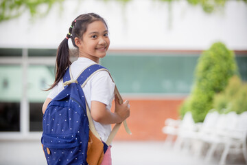 Back to school. Cute Asian child girl with a backpack running and going to school with fun