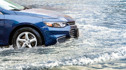 Flooding in the city after the rain. The car drives through a puddle in the pouring rain. Splashes...