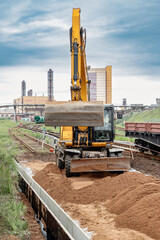 A powerful wheeled excavator prepares the site for the construction of the railway. Excavator with...