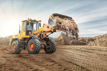 Wheel front loader bulldozer pours sand. Distributes sand for road construction. Powerful...