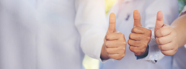 Banner Thumbs up team hand satisfaction job with positive happy good sign. Close up business people partner hand good sign. Panorama Teams trust Gesture Thumbs up together as teamwork with copy space