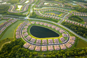 View from above of densely built residential houses near retention ponds in closed living clubs in south Florida. American dream homes as example of real estate development in US suburbs - obrazy, fototapety, plakaty