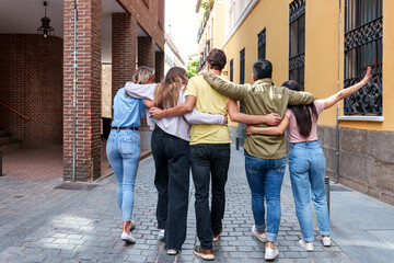 A candid shot capturing the happiness and camaraderie of five friends walking arm in arm, their...