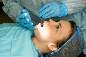 Dental surgeon examines patient's mouth