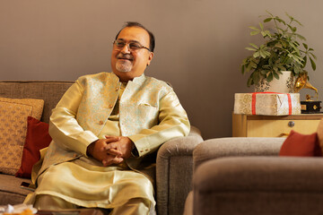 Fototapeta premium Man in traditional outfit relaxing on sofa at home