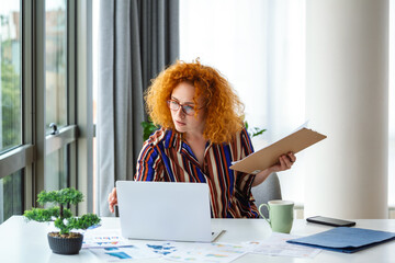 A focused businesswoman confidently presents charts and graphs during a video call, while a young...