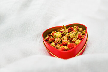 wild strawberry, in a heart-shaped box, summer picnic concept, summer strawberries