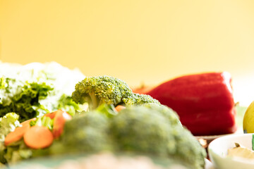 Healthy vegan food. Fresh vegetables on yellow background.