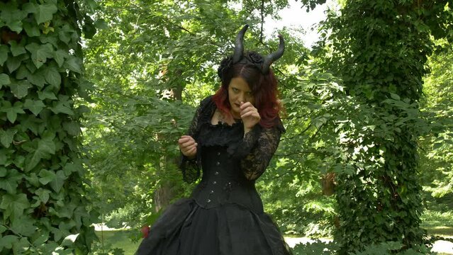 Succubus cosplay girl in the forest dancing between trees in the forest, Medium shot Slow Motion.