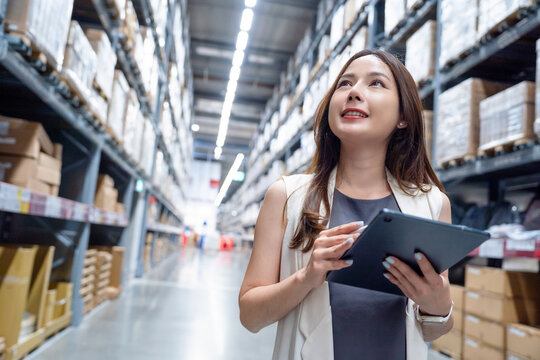 Smart asian female business owner checking product on shelf at distribution warehouse. logistic business shipping and delivery logistic service