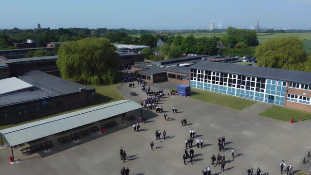 Drone shot 50fps. Birds eye view of secondary, academy school playground. School children, school yard. Filmed East Yorkshire. UK.