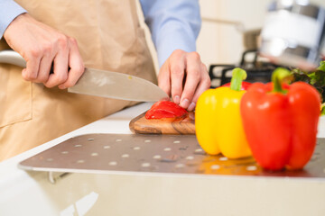 Obraz na płótnie Canvas トマトを切る若い男性　料理イメージ 