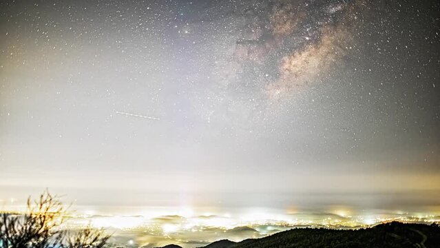 Milky Way galaxy spin above city with ultra high light pollution, time lapse