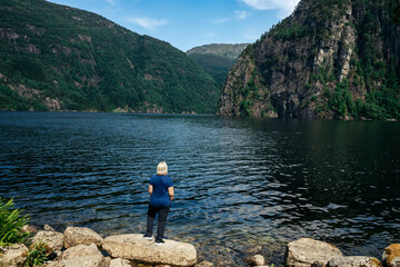 Fototapeta na wymiar Woman standing looking out at a fjord in Vestland Norway 