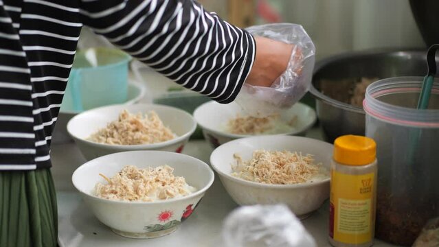 Chicken porridge seller or tukang bubur ayam is prepares his meal for customers or pelanggan. Bubur Ayam (Chicken Porridge), Malaysian Traditional Food Consist of White rice porridge with salted egg, 