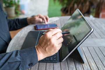 Businessman working on his tablet by using his stylus pen. Home environment.