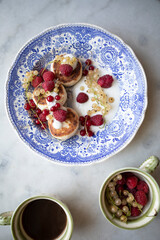 vintage plate with cottage cheese pancakes and berries. syrniki with greek yogurt, raspberries and currants.	