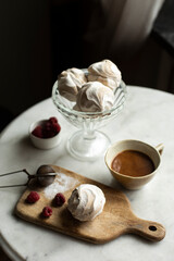 cup of coffee and zephyr on white table top view. coffee with white zephyr. sweets for breakfast	