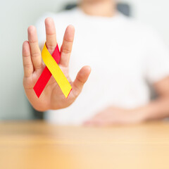 woman holding Red and Yellow ribbon. World hepatitis day awareness month, 28 July, Liver cancer,...