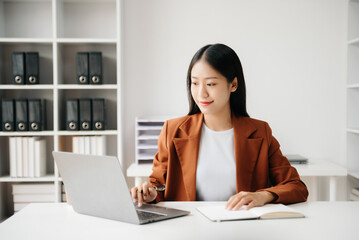 Business woman using tablet and laptop for doing math finance on an office desk, tax, report, accounting, statistics, and analytical research concept in office