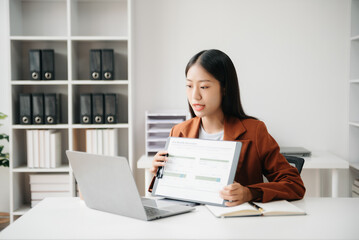 Business woman using tablet and laptop for doing math finance on an office desk, tax, report, accounting, statistics, and analytical research concept in office