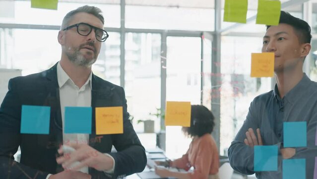 Planning, writing and business people on glass board for teamwork, brainstorming and schedule or workflow ideas. Professional men, mentor or manager with sticky notes, timeline solution and meeting