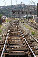 Fototapeta premium detail of the train tracks arriving at a traffic light before entering the train station